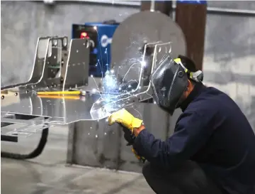  ?? — WP-Bloomberg photo by George Frey. ?? A worker welds a custom built aluminum body frame for a Venice roadster model vehicle at the Vanderhall Motor Works manufactur­ing facility in Provo, Utah.