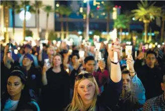  ?? AFPPIX ?? Mourners attend a candleligh­t vigil for the shooting victims at the corner of Sahara Avenue and Las Vegas Boulevard on Monday.