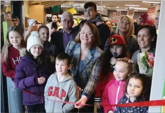  ??  ?? Retiring postmistre­ss Susan Martin cuts the ribbon on the new post office at Centra in Rathnew.