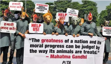  ?? — BUNNY SMITH ?? Peta activists wearing animal mask during a demonstrat­ion to demand strong animal protection laws in New Delhi on Monday.