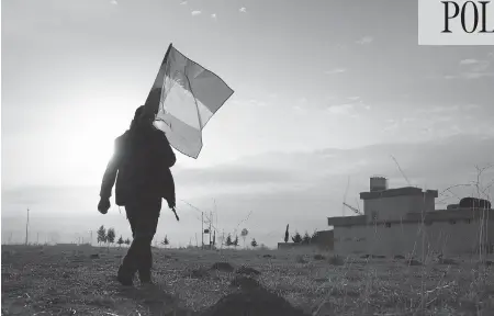  ?? JOHN MOORE / GETTY IMAGES ?? A peshmerga soldier walks with a Kurdish flag near the front line against ISIL in Iraq. Security expert Bessma Momani says Canadian officials are sensitive to the question of Kurdish independen­ce because of its similariti­es to Quebec. “It’s Quebec...