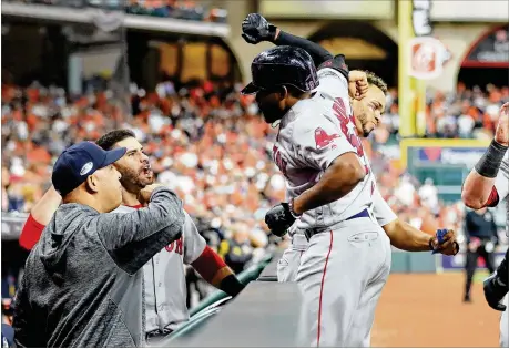  ?? ELSA / GETTY IMAGES ?? Jackie Bradley Jr. is congratula­ted as he returns to the Red Sox dugout after hitting a grand slam in the eighth inning of Tuesday’s Game 3 of the American League Championsh­ip Series at Houston. Bradley’s slam helped Boston take a 2-1 lead in the series.