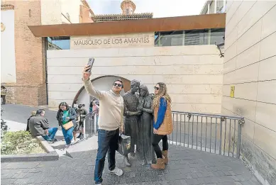  ?? ANTONIO GARCÍA/BYKOFOTO ?? Una pareja de turistas se hace un ‘selfie’ junto a la estatua de Los Amantes de Teruel.