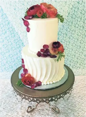  ?? JENNIFER GOLDBECK ?? For decoration­s, bakery owner Jennifer Goldbeck kept it simple, with vanilla buttercrea­m in smooth and textured finishes and fresh flowers.