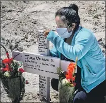  ??  ?? NORA LASSETE at the grave of Juan Velasco in Tijuana’s Municipal Cemetery No. 13. He died of COVID-19 symptoms.