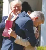  ??  ?? President Donald Trump applauds as new Supreme Court Justice Neil Gorsuch hugs his wife, Marie Louise.