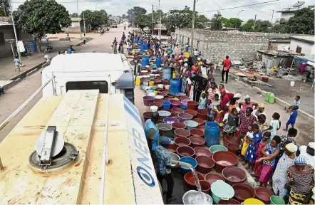  ??  ?? Precious resource: National Office of Drinking Water agents distributi­ng water to residents in Bouake.