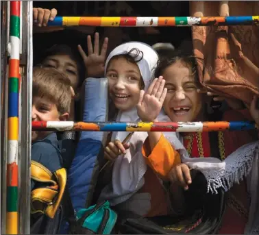  ?? ?? Children peek out of a bus Oct. 4, 2013, as they leave school in Wajah Khiel, Swat Valley, Pakistan.