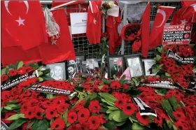  ?? AP/EMRAH GUREL ?? Floral tributes and Turkish flags along with photos of victims are displayed outside the Reina club Wednesday after the New Year’s attack in Istanbul.