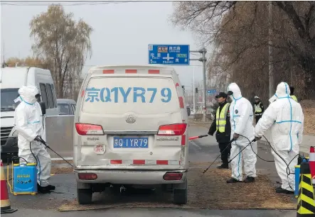  ?? NG HAN GUAN/THE ASSOCIATED PRESS FILES ?? Workers disinfect passing vehicles after an African swine flu outbreak near Beijing in November. “That virus terrifies me,” says an Alberta veterinari­an who gave a presentati­on on the disease to delegates at the Banff Pork Seminar this week.