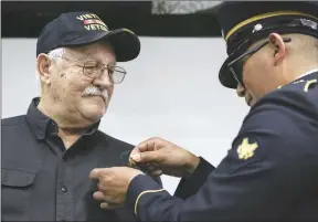  ?? Charlie Kaijo/NWA Democrat-Gazette ?? U.S. Army Specialist Robert Montez (right) places a 50th anniversar­y commemorat­ive pin on the shirt of Vietnam veteran Stan Neukircher, of Bella Vista.