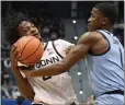  ?? JESSICA HILL — THE ASSOCIATED PRESS ?? UConn's Tristen Newton, left, who recorded a triple-double, is fouled by Marquette's Kam Jones on Tuesday.