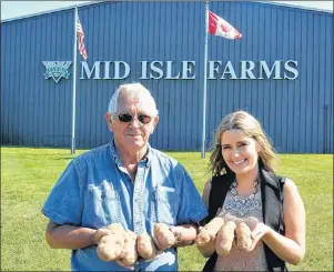  ?? COLIN MACLEAN/JOURNAL PIONEER ?? Bertie Webster, co-founder of Mid-Isle Farms Inc., and Brianna Flood, marketing co-ordinator, hold some spuds outside the company’s Albany facility. Mid-Isle Farms is celebratin­g 35 years in business this year.