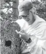  ?? BEN DANTZER ?? Ben Dantzer removes a juvenile North American red squirrel from its nest so that it can be weighed.