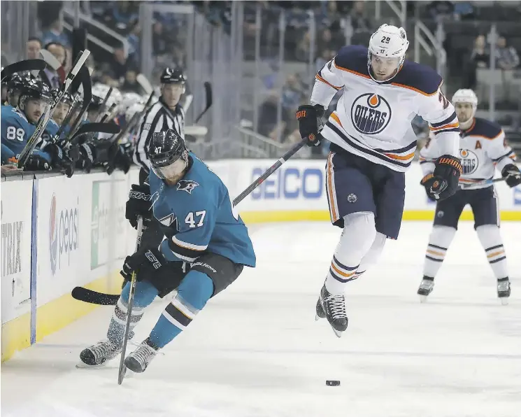  ?? TONY AVELAR/THE ASSOCIATED PRESS ?? Edmonton Oilers centre Leon Draisaitl jumps out of the way of a check by San Jose Sharks defenceman Joakim Ryan on Saturday in San Jose.