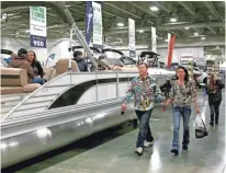  ?? RICK BARRETT / MILWAUKEE JOURNAL SENTINEL ?? Outdoor sports enthusiast­s check out the pontoon boats Saturday at the Milwaukee Journal Sentinel Sports Show at State Fair Park. Pontoons have led recreation­al boating sales in recent years.