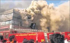  ?? PTI ?? Smoke billows from Taxshila Arcade in Surat after a fire engulfed its third and fourth floors on Friday.