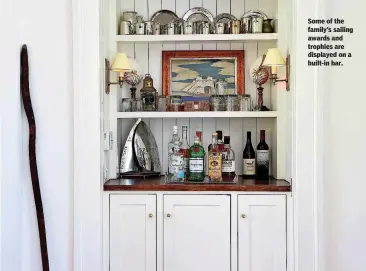  ??  ?? Some of the family’s sailing awards and trophies are displayed on a built-in bar.