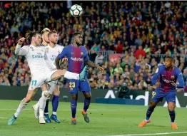  ?? AP ?? Gareth Bale (left) of Real Madrid challenges for the ball during the El Clasico in the Spanish league against Barcelona at the Camp Nou stadium in Barcelona, Spain, on Sunday. The match ended 2-2. —