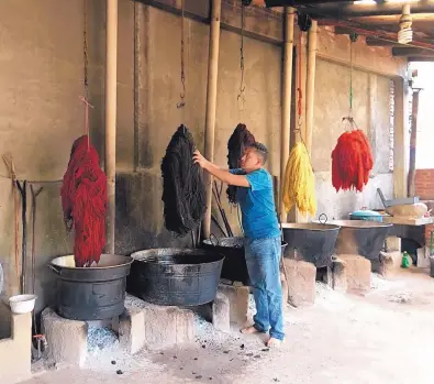  ?? COURTESY OF JAVIER LAZO ?? Weaver Porfirio Gutierrez inspects drying yarn.