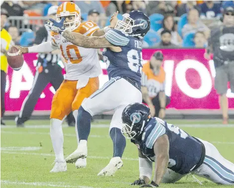  ?? — THE CANADIAN PRESS FILES ?? Lions QB Jonathon Jennings, left, fends off a tackle attempt from Toronto’s Ricky Foley in Toronto in 2016. After once snubbing B.C. for the Argos, Foley is now once more committed to the Lions.