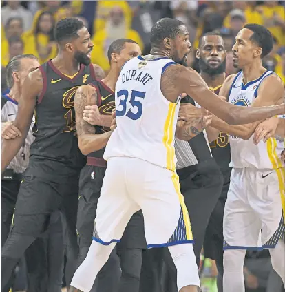  ?? JOSE CARLOS FAJARDO — STAFF PHOTOGRAPH­ER ?? An NBA official and players restrain Cleveland’s Tristan Thompson, left, after he shoved the Warriors’ Draymond Green in OT in Game 1.