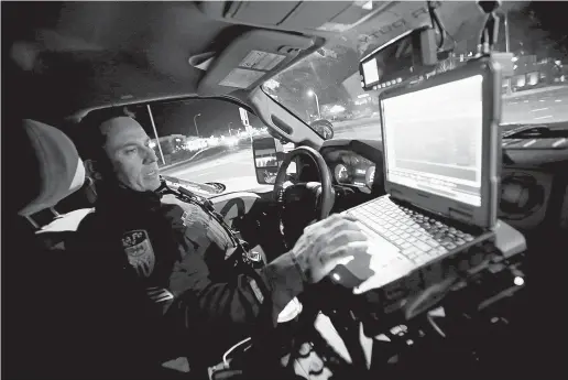  ?? PHOTOS BY LUIS SÁNCHEZ SATURNO/THE NEW MEXICAN ?? Sgt. Bryan Martinez checks his computer at a traffic light before heading downtown Thursday. In a medium-sized city confrontin­g the gamut of big-city crime, the person who succeeds Patrick Gallagher as chief of the Santa Fe Police Department will move...