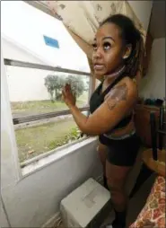  ?? AP PHOTO/ROGELIO V. SOLIS ?? In this Feb. 20 photo, Whitley Williams demonstrat­es how a recently repaired window does not open easily, preventing her from using a window air conditione­r to help cool her apartment in Cedarhurst Homes, a federally subsidized, low-income apartment complex in Natchez, Miss.