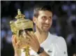  ?? BEN CURTIS — ASSOCIATED PRESS ?? Novak Djokovic holds his trophy after defeating Kevin Anderson in the men’s final in London on Sunday.