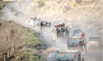  ?? — AFP ?? People who fled the IS group’s last holdout of Baghouz, in Syria’s northern Deir Ezzor province, ride in the back of trucks in an area controlled by the Kurdish-led Syrian Democratic Foces (SDF).