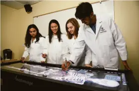  ?? MARK KOCINA ?? Students work at an anatomy table at the Harker School in San Jose.