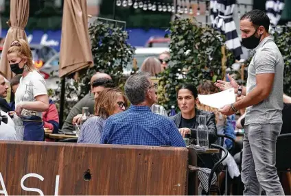  ?? Steven Senne / Associated Press ?? Patrons dine at a sidewalk cafe last week in Boston. COVID-19 deaths in the U.S. have tumbled to an average of just over 600 per day.