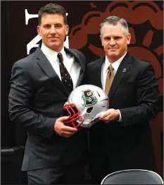  ?? Photo by Ernest A. Brown ?? James Perry, standing with Brown University Athletic Director Jack Hayes during the December 2018 press conference that announced Perry as the school’s football head coach, will be in Smithfield on Saturday afternoon (2 o’clock kickoff) as the Bears open the 2019 season against Bryant. Before heading to Brown, Perry coached the Bulldogs for two seasons.