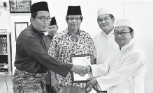  ??  ?? Jais Bintulu officer Aswat Osen (left) presents the certificat­e of approval from the department to Surau Al-Hijrah chairman Hussaini Morni, as Mohammad Medan (centre) and others look on.