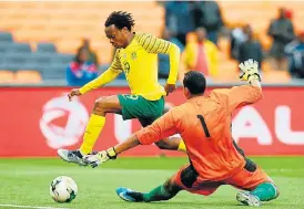  ?? /AFP ?? Deft footwork: Percy Tau beats Seychelles goalkeeper Romeo Barra to score on Saturday.