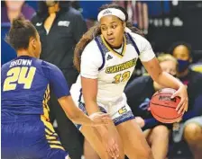  ?? STAFF PHOTO BY ROBIN RUDD ?? UTC’s Bria Dial dribbles outside the 3-point line as UNC Greensboro’s Jaylynn Brown defends during Friday’s game at McKenzie Arena. Dial scored a game-high 16 points, and the Mocs never trailed, leading 34-17 at halftime and winning 57-41.