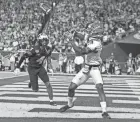  ?? ?? Georgia wide receiver Adonai Mitchell catches a touchdown pass as Michigan defensive back Vincent Gray looks on during the Orange Bowl.