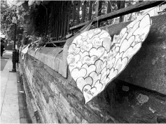  ??  ?? Students’ paper hearts are strung along a wall near London’s Southwark Cathedral as a makeshift memorial for attack victims. In their handwritte­n messages, the children express their love for London and wish for peace.