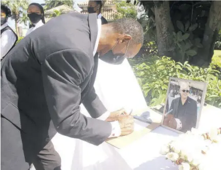  ?? (Photos: Philp Lemonte) ?? Dalton “Red Youth” Smith, the longest-serving employee at Sandals, signs the condolence book opened for Gordon “Butch” Stewart at Sandals Montego Bay yesterday.