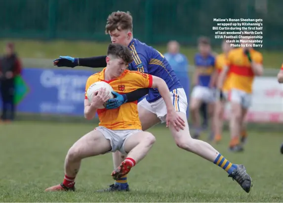  ?? Photo by Eric Barry ?? Mallow’s Ronan Sheehan gets wrapped up by Kilshannig’s Bill Curtin during the first half of last weekend’s North Cork U21A Football Championsh­ip clash in Mourneabbe­y