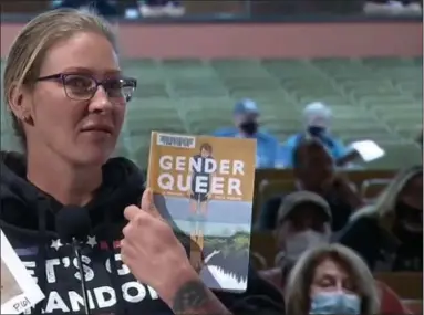  ?? SCREENSHOT FROM NPTV VIDEO ?? Carrie Rocks of Upper Gwynedd holds a copy of “Gender Queer” after reading excerpts, some containing graphic content, to the North Penn school board on Thursday.