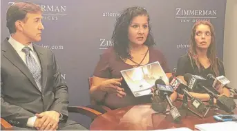  ?? MITCHELL ARMENTROUT/SUN-TIMES ?? Michelle Urrutia (center) shows a photo of a Cook County holding cell at a Wednesday press conference alongside attorney Thomas Zimmerman and Elizabeth Alicea (right).