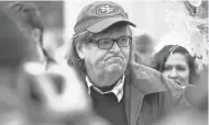  ?? JASPER COLT, USA TODAY ?? Documentar­y filmmaker Michael Moore speaks with protesters in Washington. CONTINUED FROM 1A