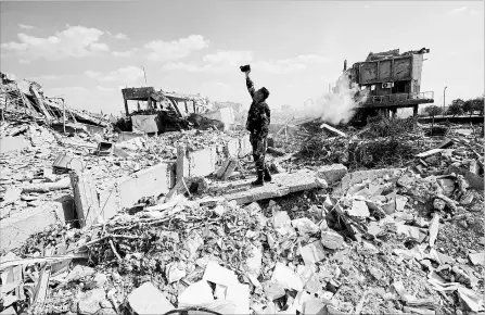  ?? HASSAN AMMAR THE ASSOCIATED PRESS ?? A Syrian soldier videos the damage to the Syrian Scientific Research Center in Barzeh, near Damascus, which was hit by U.S., British and French military strikes to punish President Bashar Assad for suspected chemical attack against civilians.