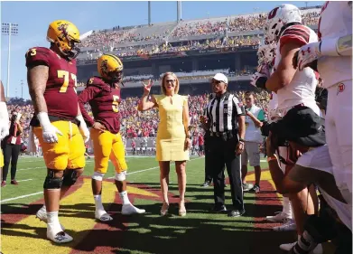  ?? CHRISTIAN PETERSEN / GETTY IMAGES ?? Democratic U.S. Senate candidate Kyrsten Sinema participat­es in the pre-game coin toss before Saturday’s game between the Utah Utes and the Arizona State Sun Devils at Sun Devil Stadium in Tempe, Ariz.