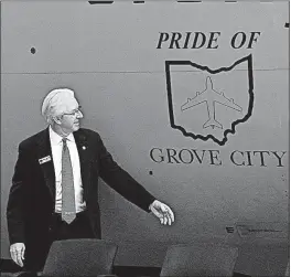  ??  ?? Grove City Mayor Richard “Ike” Stage unveils the new “Pride of Grove City” emblem on the KC-135 Stratotank­er in a ceremony at Rickenback­er Air National Guard Base on Thursday.