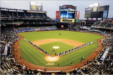  ?? AP PHOTO BY FRANK FRANKLIN II ?? The Miami Marlins and the New York Mets joins members of the New York police and fire department­s on the field for pregame ceremonies before a baseball game Tuesday, Sept. 11, in New York.