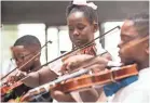  ??  ?? Ja’lyla Austin, 9, focuses while performing with the Harmonic South String Orchestra in the Crosstown Concourse Central Atrium on Wednesday, June 27. BRAD VEST/THE COMMERCIAL APPEAL