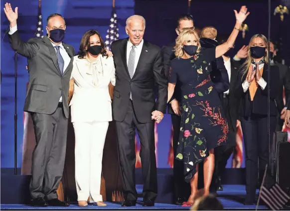  ?? PHOTOS BY JIM LO SCALZO/EPA-EFE ?? President-elect Joe Biden and Vice President-elect Kamala Harris, flanked by their spouses, celebrate in Wilmington, Del., on Saturday.