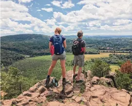  ?? Connecticu­t Forest and Park Associatio­n/Contribute­d photo ?? A pair of hikers at a scenic overlook in Guiffrida Park in Meriden on the New England Scenic Trail.